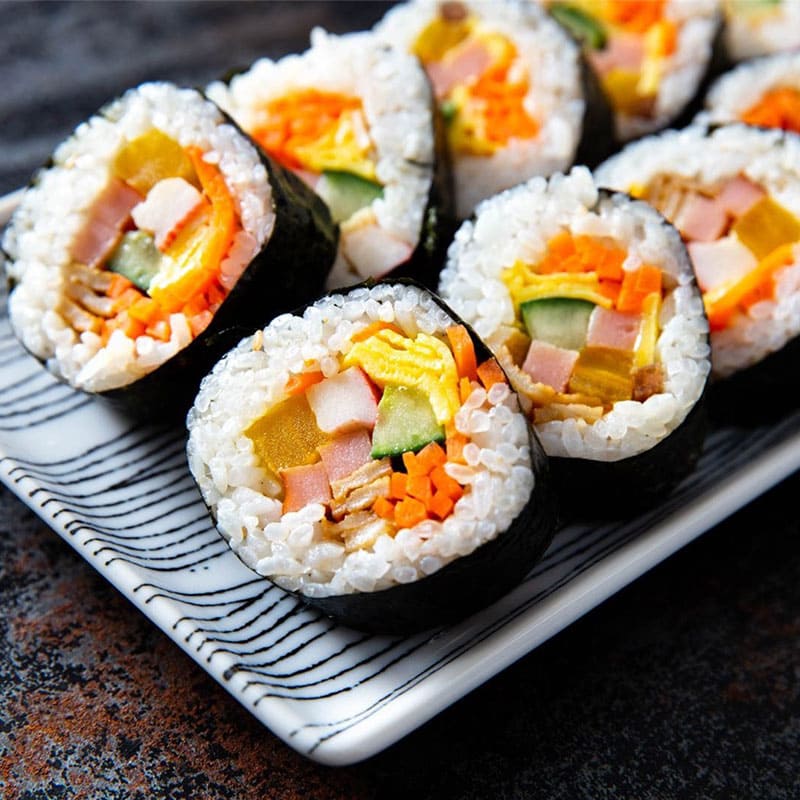 món ăn hàn quốc Kimbap là cơm cuộn Hàn Quốc với rau, thịt và trứng, cuộn trong rong biển