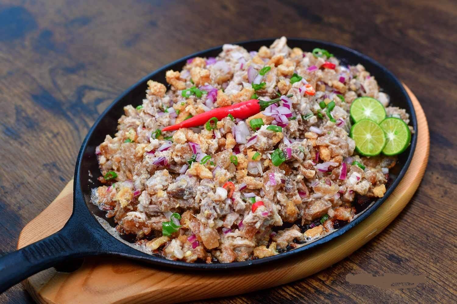 ẩm thực philippines Sisig là món ăn nổi tiếng Philippines với thịt băm nóng hổi, vị chua mặn đậm đà, thường ăn kèm cơm